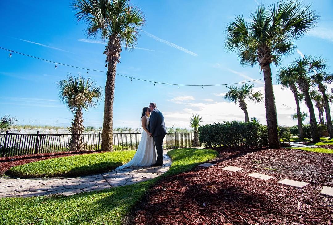 Bride and groom with ocean in the background at Hampon Inn Jax Beach
