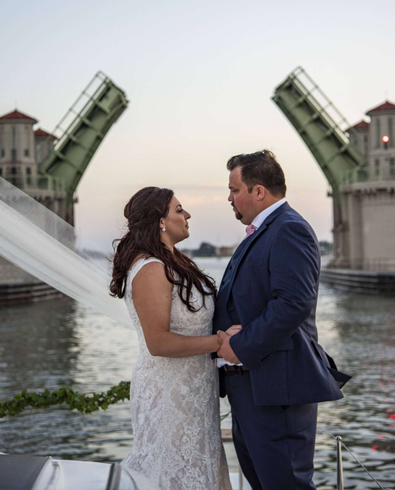 Bride and groom on the sail boat in front of the Bridge of Lions