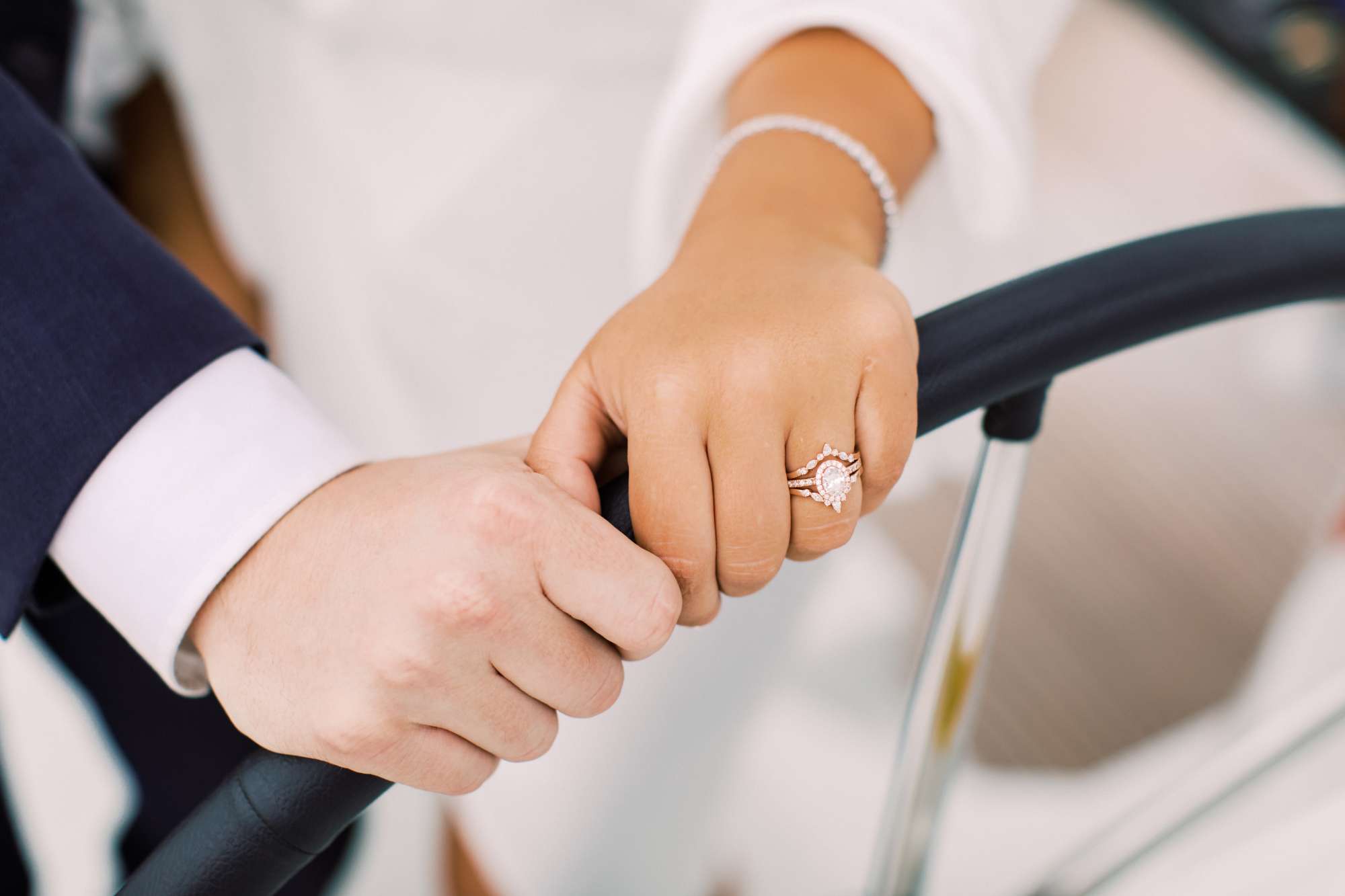 Showing off the wedding rings on the sail boat steering wheel