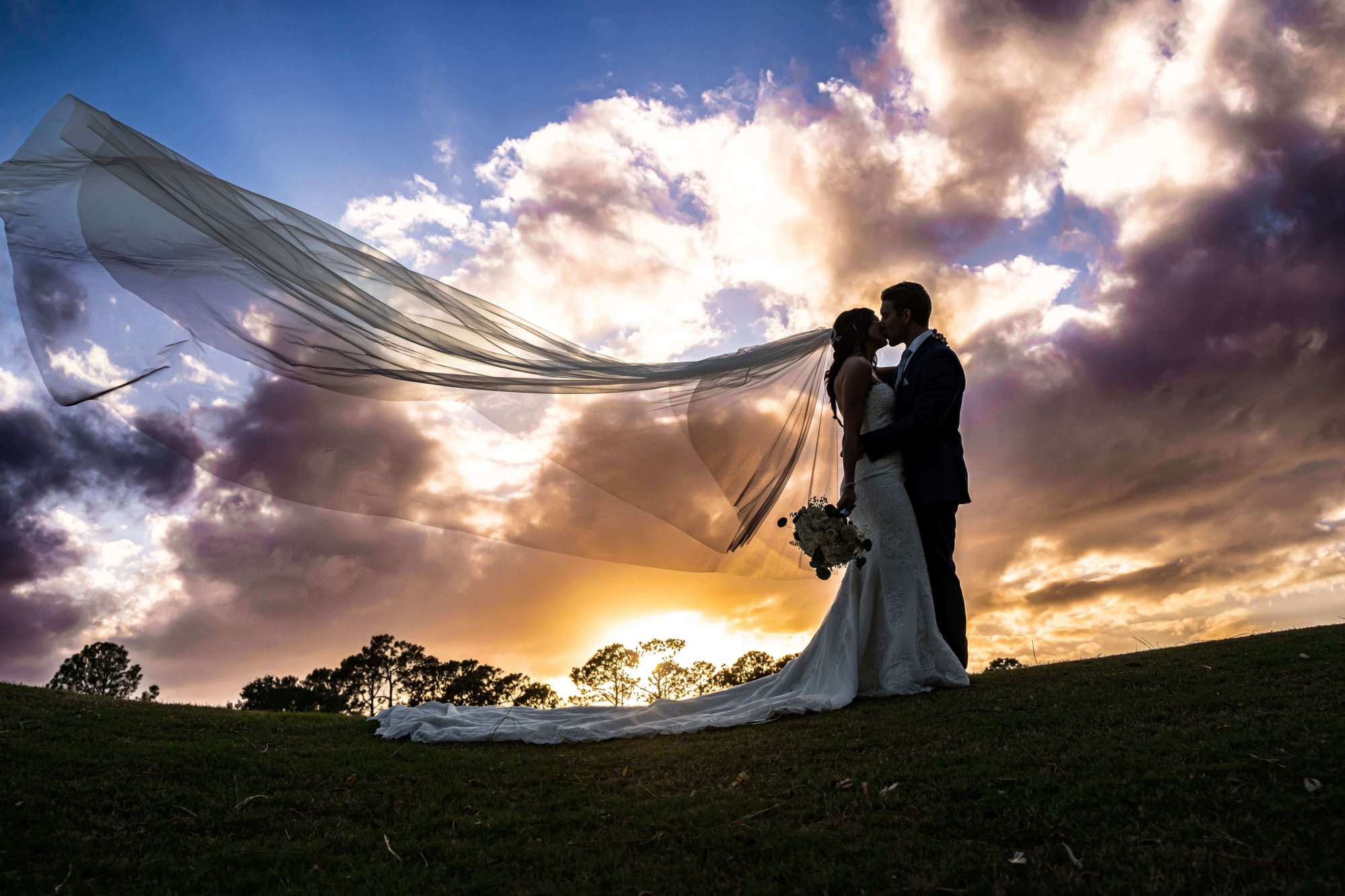 Bride with long veil against pretty sunset in St. Augustine Florida. Breathless Imagery and Premier Bride of the 904